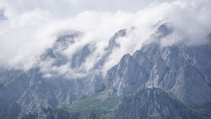 Mountain landscape with the clouds passing through the top of them