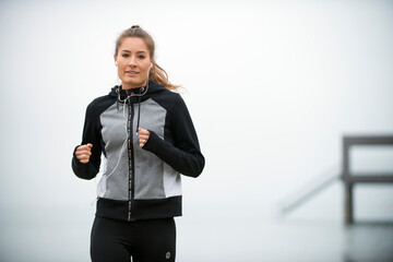 Germany, Leutkirch, Portrait of woman in sports clothing jogging on beach