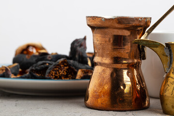 Copper turk with coffee and dried fruit pieces on table