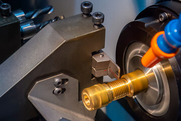 Close up scene the CNC lathe machine thread cutting at the end of brass pipe coupling parts.