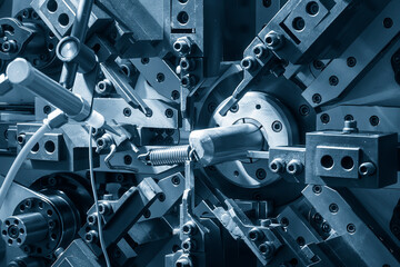 Close up the coil spring machine in light blue scene.