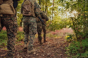 A group of modern warfare soldiers is fighting a war in dangerous remote forest areas. A group of soldiers is fighting on the enemy line with modern weapons. The concept of warfare and military
