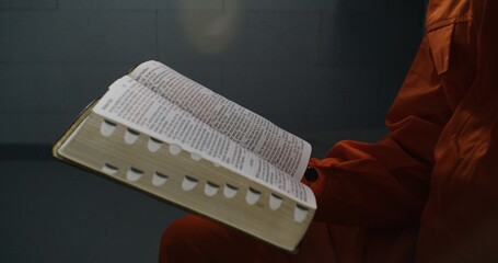 Close up shot of Bible. African American prisoner holds book in hand, reads, flips through pages....
