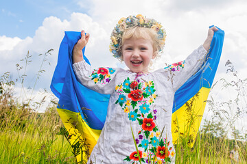 flag of Ukraine is on the shoulders of a little Ukrainian girl. Happy Ukrainian child in free...