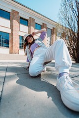 Vertical view of girl performing hip hop dance style having fun freestyle dancer in urban city