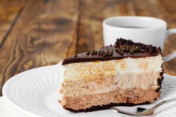 Piece of chocolate cake on white plate on table