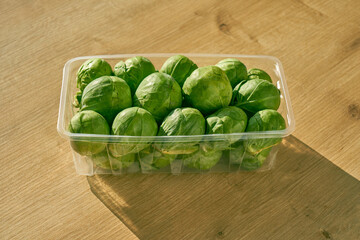 Sliced Brussels sprouts and a chefs knife on a wooden kitchen counter. 