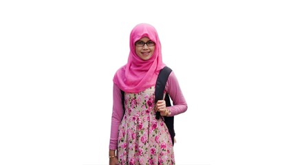Close up portrait of young Muslim woman wearing pink hijab and dress with red rose flower motif and eyeglasses holding black backpack strap. Smiling and happy expression.