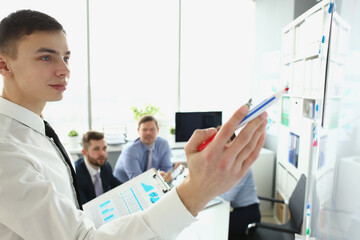 Businessman presentation coach draws plan writing plan on board. Intern student presenting new...