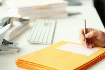 Person fill in address on yellow envelope of postal correspondence for application hiring concept....