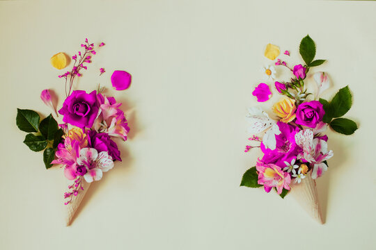 Two improvised flower ice creams of purple or pink roses and alstroemeria left and right photo, empty space in center, flat lay. Seasonal garden flowers blank for invitation, card or advertisement