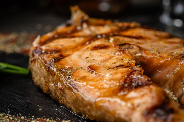 Red salmon fish with Indian spices on a black background.