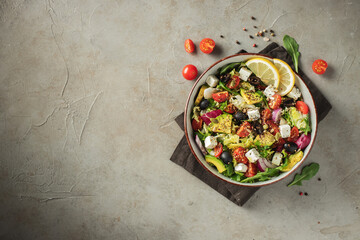Delicious and healthy green salad of different leaves and vegetables with seeds and olive oil.