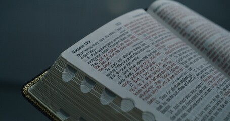 African American prisoner in orange uniform reads Bible in prison cell. Male criminal serves imprisonment term for crime in jail. Detention center or correctional facility. Concept of faith in God.
