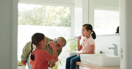 Father brushing his teeth with his children in the bathroom of their modern family home together. Hygiene, teaching and young dad bonding and doing a dental care routine with girl kids at their house