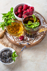 a cup of tea on a wooden stand, oriental style, mint, lavender, raspberry bowl.