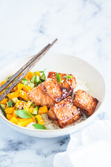 Teriyaki salmon with rice and mango in white bowl. Asian cuisine concept.