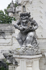 Fototapeta na wymiar Balinese white sandstone statue in front of temple