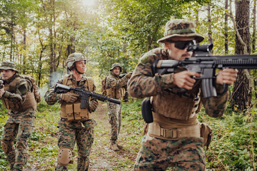 Fototapeta premium A group of modern warfare soldiers is fighting a war in dangerous remote forest areas. A group of soldiers is fighting on the enemy line with modern weapons. The concept of warfare and military