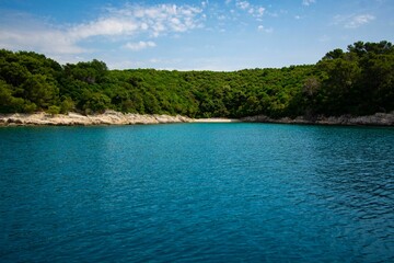 Stunning shot of a tranquil blue and green body of water during the bright mid-day sun