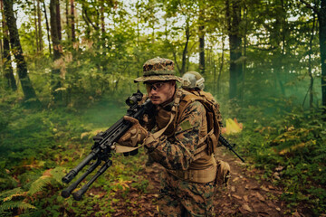 Fototapeta premium A group of modern warfare soldiers is fighting a war in dangerous remote forest areas. A group of soldiers is fighting on the enemy line with modern weapons. The concept of warfare and military