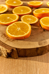 Slices of fresh organic oranges on a wooden kitchen table.