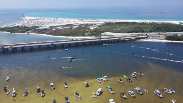 Crab Island with dense of tourist boats, yachts near Destin Bridge or William T. Marler Bridge, overlooking white sandy Eglin Beach Park along Gulf Coast in Destin, Florida, USA