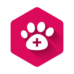 Obraz premium White Veterinary clinic symbol icon isolated with long shadow background. Cross hospital sign. A stylized paw print dog or cat. Pet First Aid sign. Pink hexagon button. Vector