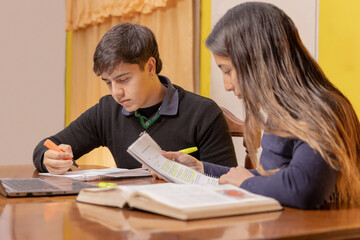 Naklejka premium A boy and a girl studying at home with books and a notebook.
