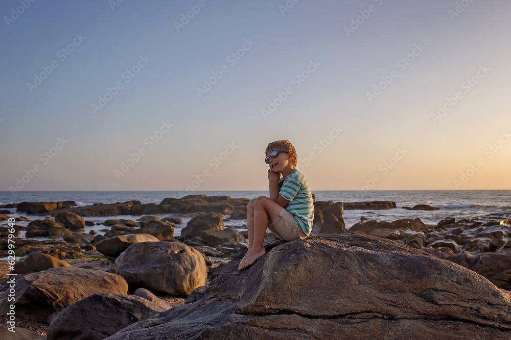 Canvas Prints Happy children, enjoying sunset over the ocean with their family, rocky beach