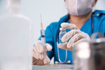 Medicine doctor is filling the medical syringe. Physicain is dawing medicine solution for her...