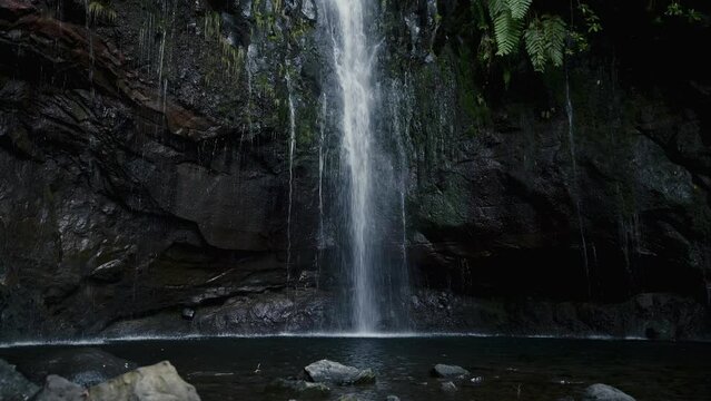 Big amazing waterfall in the final point of popular hiking route levada 25 fontes on the island of Madeira, Portugal, in the atlantic ocean