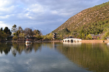 Fototapeta na wymiar Black Dragon Pool : chinese style bridge on the lake in the park in lijiang old town, the world heritage site of UNESCO