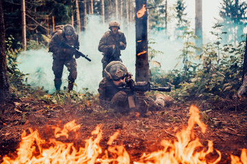 Fototapeta na wymiar Modern warfare soldiers surrounded by fire fight in dense and dangerous forest areas