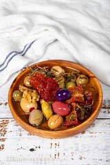 Olive salad at wooden bowl. Mixed olives on a white wood background. Mediterranean food. vegan food