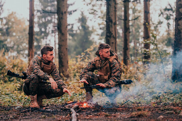 Two exhausted soldiers sitting by the fire after a weary and heavy war battle