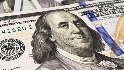 Close-up of Benjamin Franklin. One hundred US dollars. Cash banknotes. $100 bills. Background of...