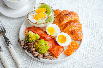 Breakfast croissants with yogurt, boiled eggs and bacon.