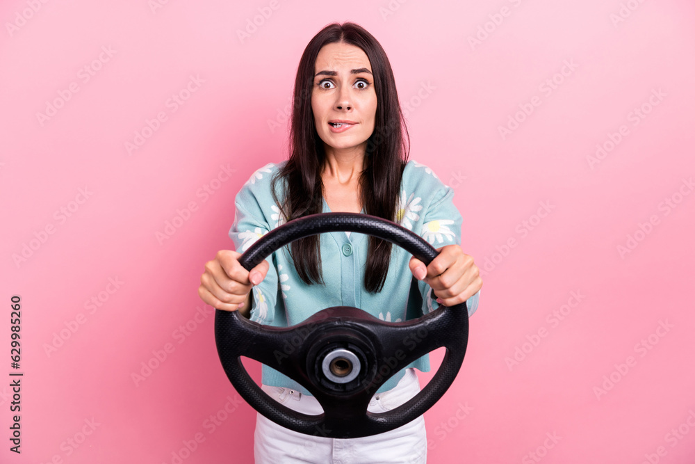 Sticker Photo of nervous confused woman with long hairstyle dressed blue cardigan hold steering wheel biting lip isolated on pink color background