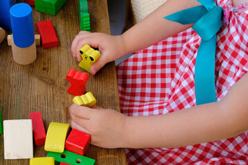 Girl play with educational toy on table in the children's room, childcare center, concept...