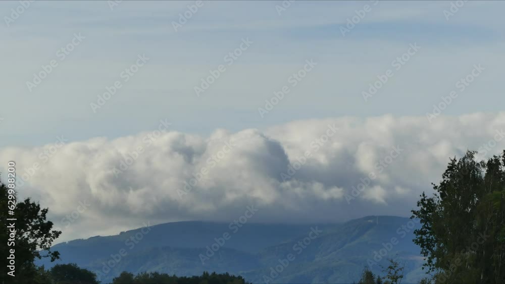 Poster view with very fast moving clouds in sky over silesian beskid mountains in poland with peak of szynd