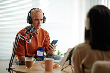 Fototapeta na wymiar Press representative talking to guest at radio show