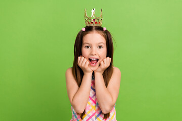 Photo of impressed astonished cute girl wear stylish costume golden crown halloween theme party isolated on green color background © deagreez