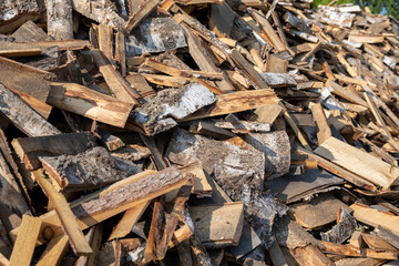 A large pile of different sawn firewood for the stove. Preparing firewood for the winter. Firewood background.