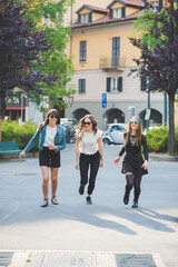 Three young women millennials outdoor in the city running and jumping