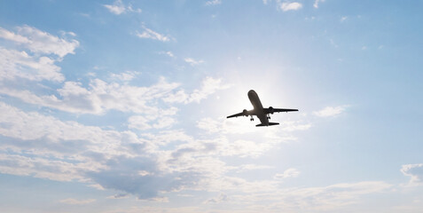 Airplane in the sky at sunset. Air transportation.  Travel. Airplane Takes Off Against the Background of Blue Sky. 