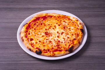 plate with margherita pizza on gray wooden table