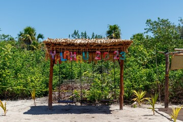 Sign of Yalahau lagoon with colorful letters and wooden swings.