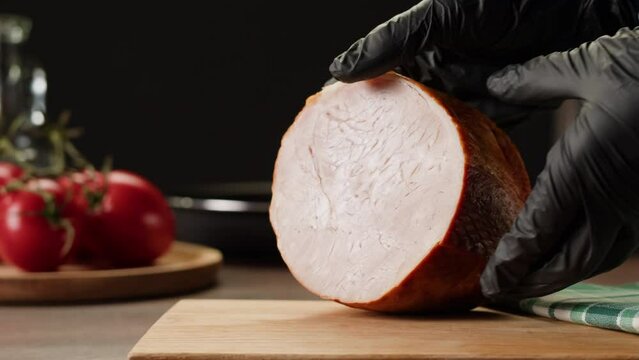 Woman slices ham bacon meat thick pieces on a wooden board, beef or pork jamon. Chef cooking breakfast, smoked bacon in cafe. 