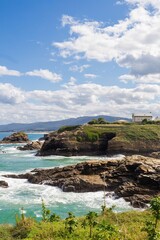 Vertical shot of rocky cliffs and stone formations near the shore in Galicia, Spain